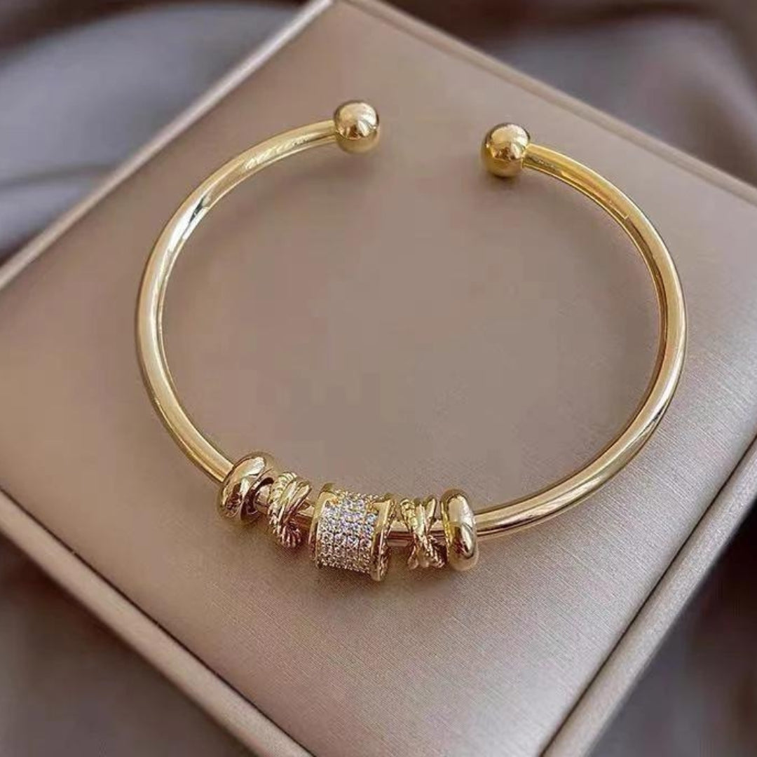 Justerbart armband med guldfärgade berlocker