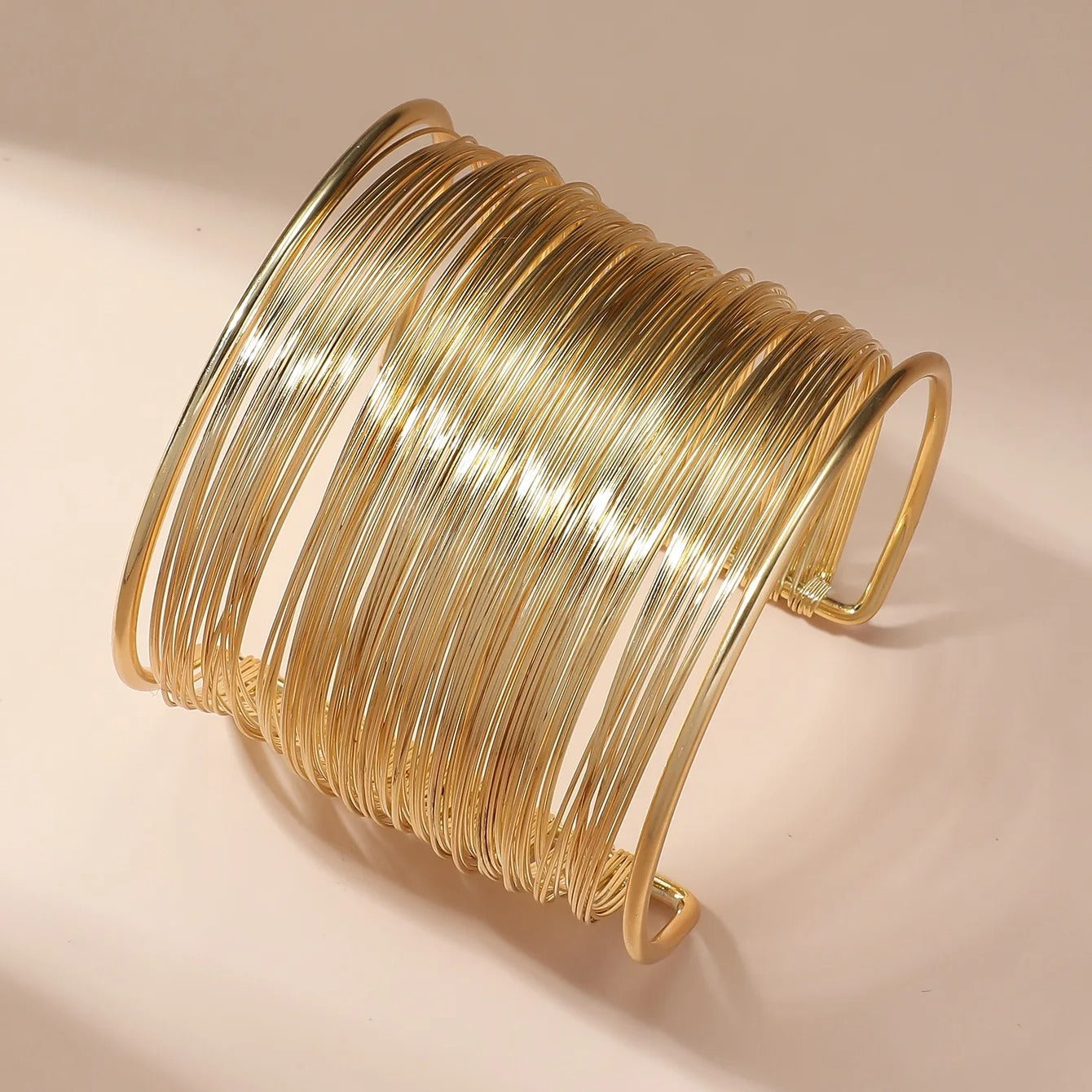 Öppet guldarmband med spiraldesign