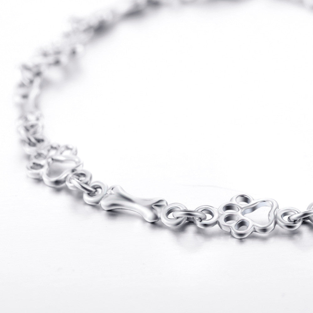Armband i begränsad upplaga med berlocker i massivt silver formade som hundtass och ben